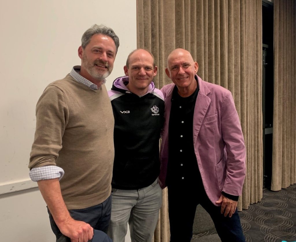 Paul Fleay, Matt Popham and comedian Peter Rowsthorn smile at the camera
